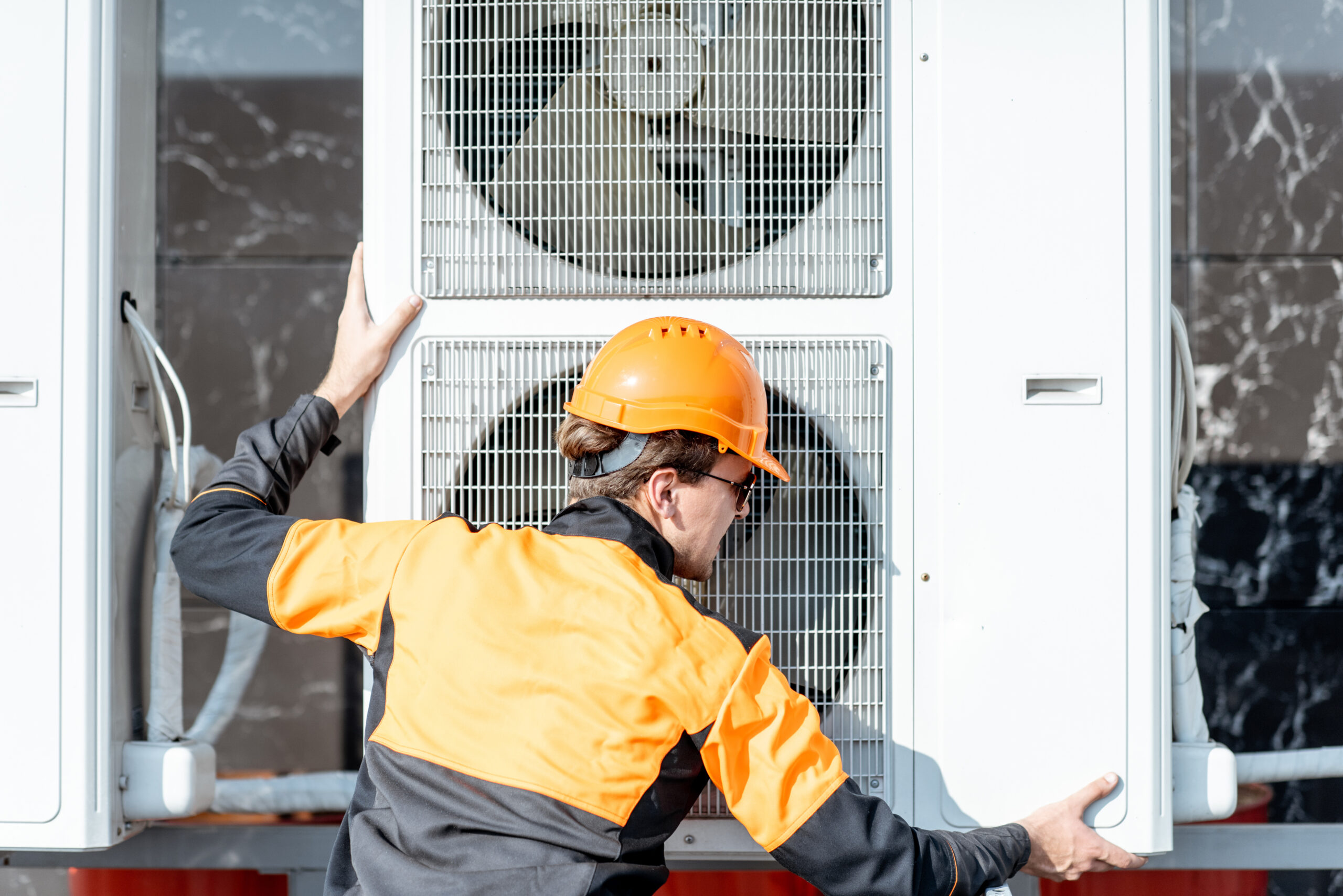 Technicien intervenant sur une unité de climatisation